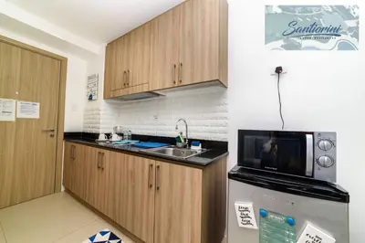 a kitchen with a sink and a microwave and a refrigerator at Santiorini at Shore Residences in Manila