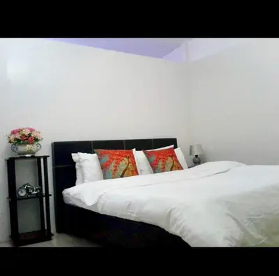 a bedroom with a bed with white sheets and pillows at Estien’s Cozy Condotel to Stay in Imus