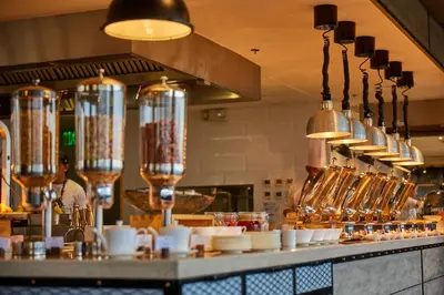 a kitchen with a counter with plates and utensils at Brittany Hotel BGC in Manila