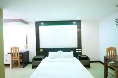 a bedroom with a white bed and a large screen at OYO 195 Ranchotel - Biñan in Biñan
