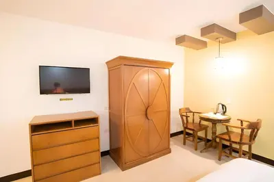 a room with a cabinet and a table with chairs at OYO 195 Ranchotel - Biñan in Biñan