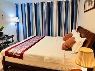 a bedroom with a bed with blue curtains at ONE UPTOWN \uff08BGC\uff09 in Manila