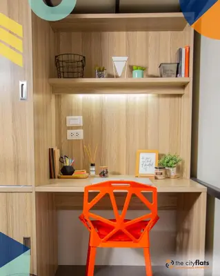 a desk with a orange chair in a room at The City Flats Amorsolo in Manila