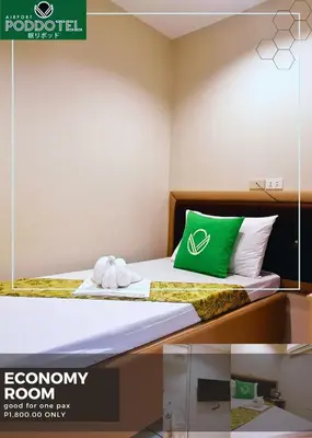 a hotel room with a bed with a green pillow at Airport Poddotel Inc. in Manila