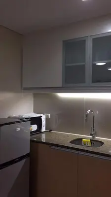 a kitchen with a sink and a refrigerator at SIBARIAN Condo unit C1 10th Floor in Manila