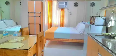a bedroom with a bed and a kitchen with a sink at SIBARIAN Condo unit C1 10th Floor in Manila