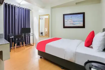a bedroom with a bed with red pillows on it at Anglo Residences Manila in Manila