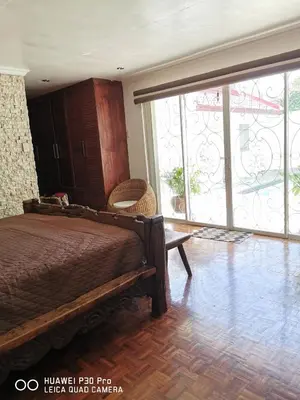 a bedroom with a bed and a large window at Casa Meyer's BF Homes International House for rent with pool and Jacuzzi in Manila