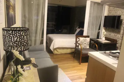 a living room with a bedroom with a bed and a couch at AZURE C4 BEACHPOOL balcony wifi MULTIPLE UNITS in Manila