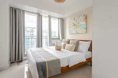 a bedroom with a large bed and a large window at Sabrina'sCrib Apartment 2BR by Azure Residences Near Manila International Airport in Manila