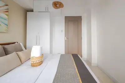 a living room with a white couch and a door at Sabrina'sCrib Apartment 2BR by Azure Residences Near Manila International Airport in Manila