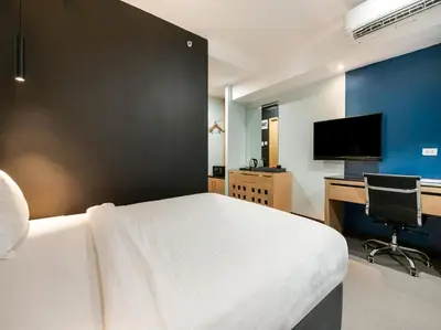 a bedroom with a bed and a desk and a television at Bay Area Suites Manila in Manila