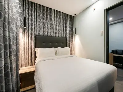 a bedroom with a large white bed and a window at Bay Area Suites Manila in Manila
