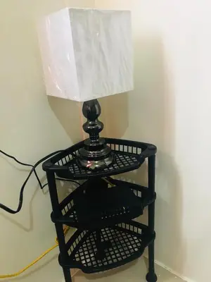 a black lamp on a shelf with a phone at Shanilyn Residency Urban Deca Towers EDSA mandaluyong Unlimited INTERNET AND NETFLIX in Manila