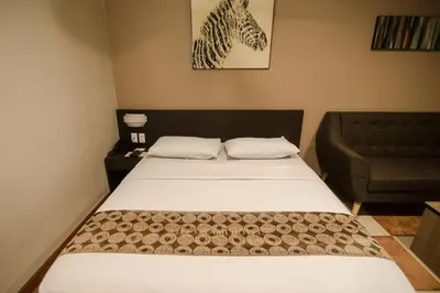 a small bedroom with a bed and a couch at DG Grami Hotel in Manila