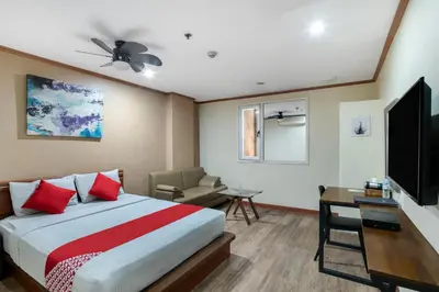 a hotel room with a bed and a television at DG Grami Hotel in Manila