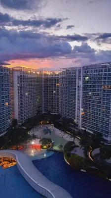 an aerial view of a large building at sunset at Azure Urban Resort Residences, Condo, Manila Airport, Wave-Pool, Tropical Vibe in Manila