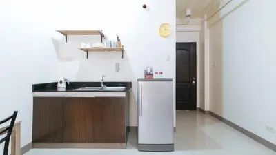 a kitchen with a sink and a refrigerator at RedDoorz at Kassel Residences Parañaque in Manila