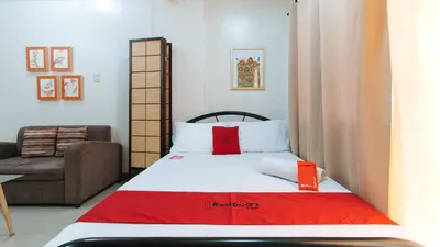 a small bedroom with a bed and a couch at RedDoorz at Kassel Residences Parañaque in Manila