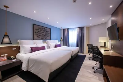a hotel room with a large bed and a desk at Coro Hotel in Manila