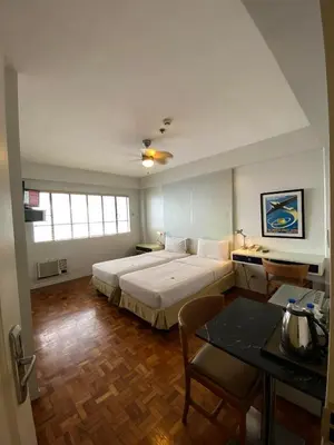 a bedroom with a large bed and a table at The Clipper Hotel, Poblacion Makati in Manila