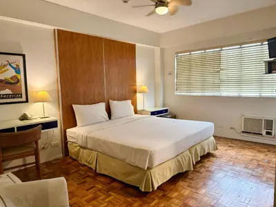 a bedroom with a large white bed and a window at The Clipper Hotel, Poblacion Makati in Manila
