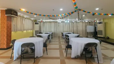 a room with white tables and chairs with lights at RedDoorz Plus at MM Hotel Las Pinas former RedDoorz Plus Near Bamboo Organ in Manila
