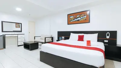 a bedroom with a large bed and a tv at RedDoorz Plus at Evangelista Street Makati in Manila
