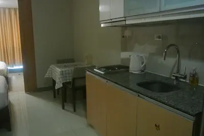 a small kitchen with a sink and a table at ONE UPTOWN RESIDENCE in Manila