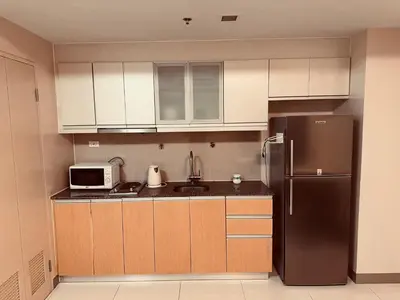a kitchen with a refrigerator and a microwave at ONE UPTOWN RESIDENCE in Manila