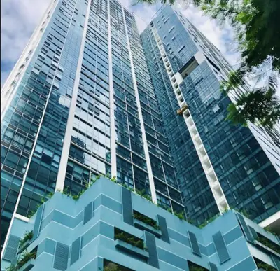 a tall blue building with a lot of windows at ONE UPTOWN RESIDENCES in Manila