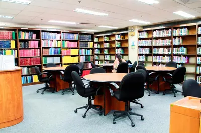 a library with tables and chairs and books at AIM Conference Center in Manila