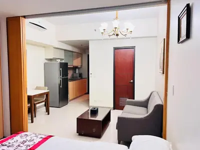 a living room with a couch a chair and a table at ONE UPTOWN residence SW14M 9TH AVENUE ST \u516c\u5bd3 in Manila