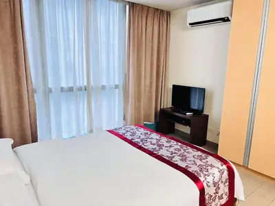 a hotel room with a bed and a television at ONE UPTOWN residence SW14M 9TH AVENUE ST \u516c\u5bd3 in Manila