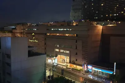a night view of a large building with a street at MANDALUYONG 2 Br w 2 Queen, 50HDtv across Shangrila Mall in Manila