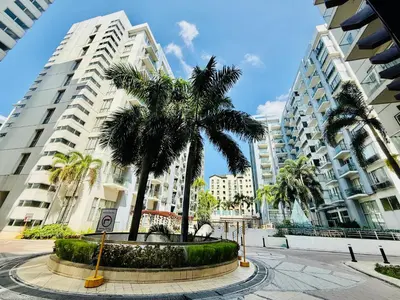 a street with palm trees and tall buildings at One Palm Tree Villas across NAIA-T3 in Manila