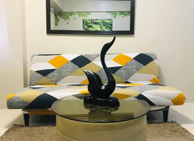 a living room with a couch and a table with a statue at One Palm Tree Villas across NAIA-T3 in Manila