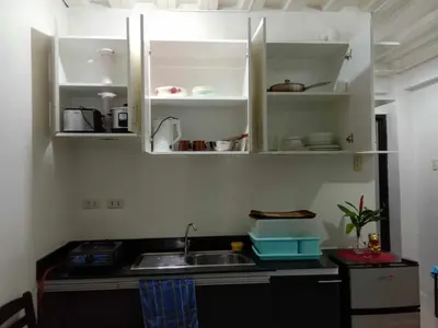 a kitchen with a sink and white cabinets at Jen's Apartment in Manila