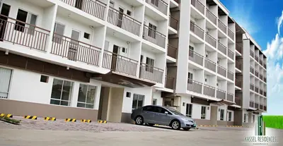 a car parked in front of a large apartment building at Jen's Apartment in Manila