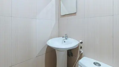 a white bathroom with a sink and a toilet at RedDoorz at Ranchotel Bayanan Alabang in Manila