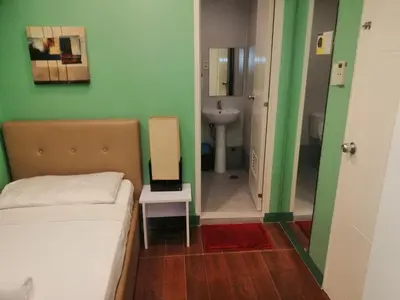 a bedroom with a bed and a bathroom with a sink at ANNELENA INN in Manila