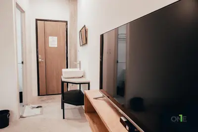 a living room with a tv and a table and a chair at One Biñan Place in Biñan