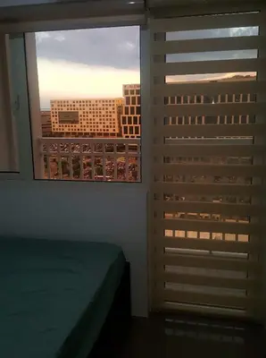 a bedroom with a window with a view of a city at A SPECIAL PLACE Shore Residences in Manila