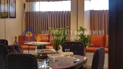 a dining room with a table and chairs and a window at East Bay Residences @ Sucat Muntinglupa in Manila
