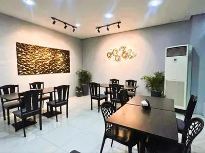 a restaurant with tables and chairs and a painting on the wall at Arzo Hotel Grand Lodge in Manila