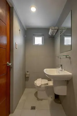 a bathroom with a toilet and a sink at iHotel Uptown BGC in Taguig