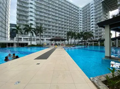 a large swimming pool in front of a large building at Cozy Space at Shell Residences in Tower A in Manila