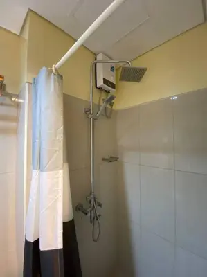 a shower in a bathroom with a shower curtain at Cozy Space at Shell Residences in Tower A in Manila