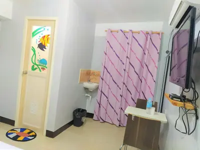 a room with a pink curtain and a television at JB Valdres Apartment in Manila