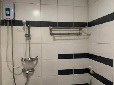 a shower in a bathroom with black and white tiles at Lucky Hotel Binondo in Manila